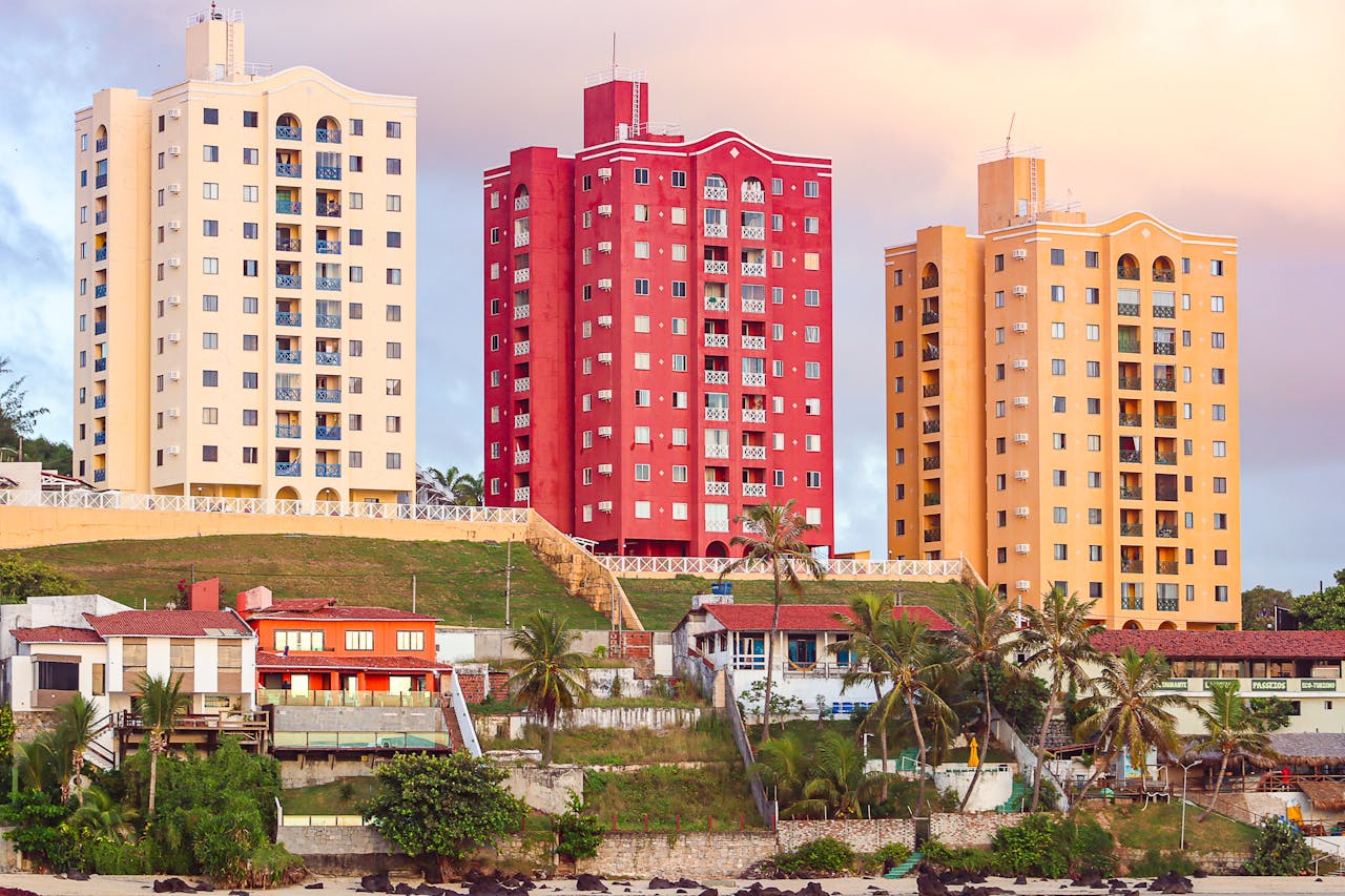 Colorful beachfront apartment towers surrounded by palm trees and coastal homes