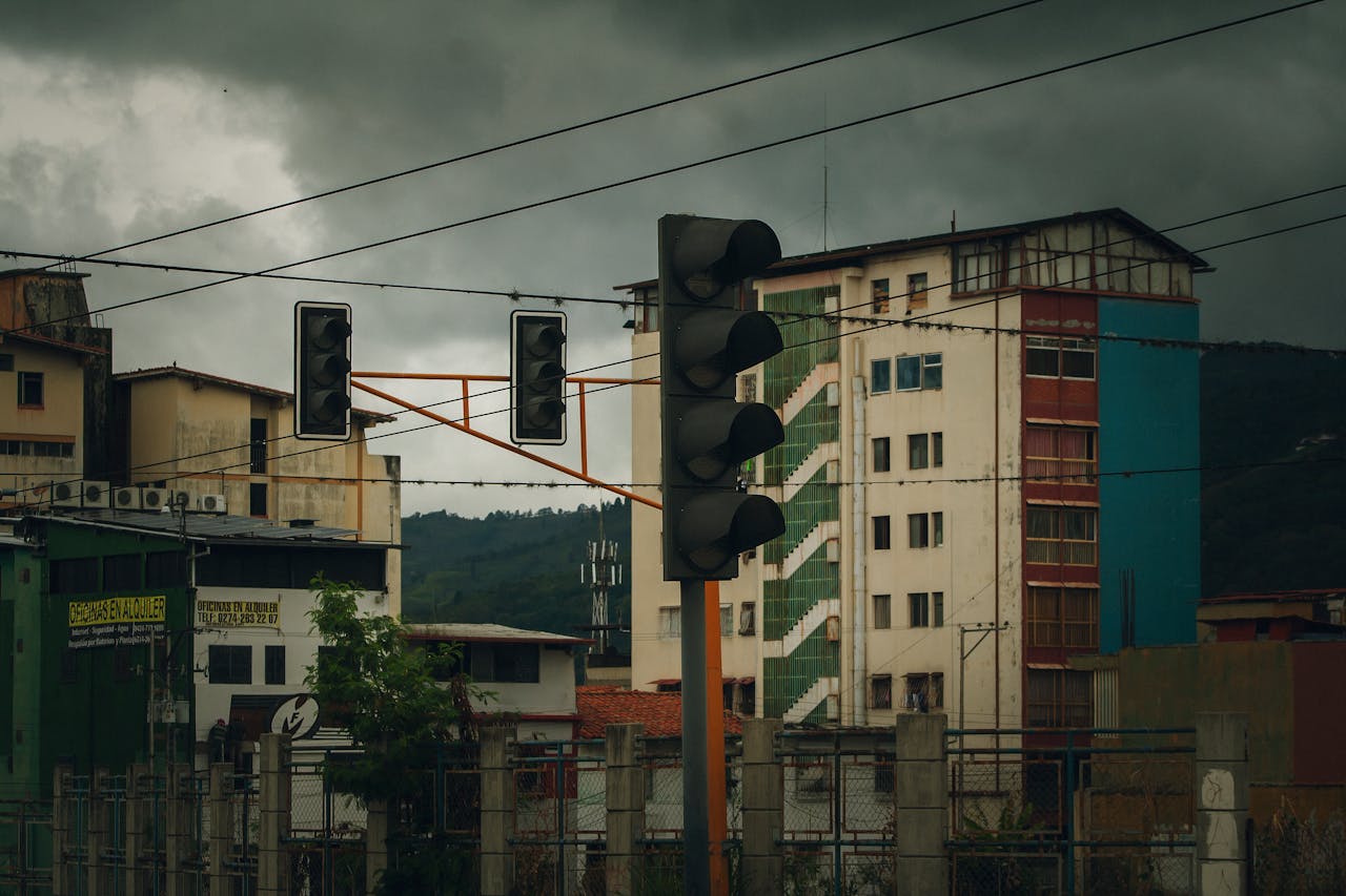 Urban intersection with traffic lights and residential buildings under cloudy skies