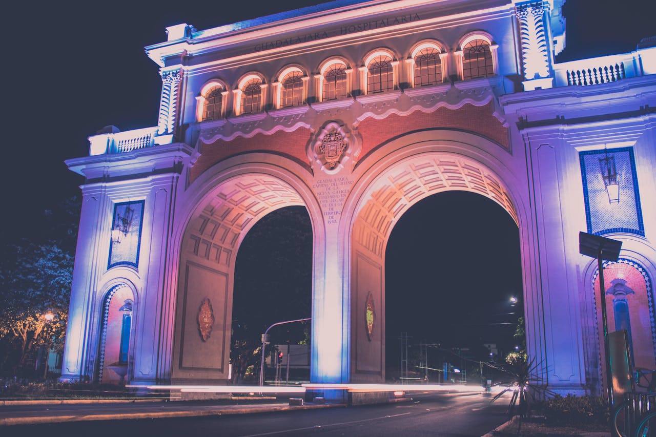 Illuminated historic archway in Guadalajara photographed at night