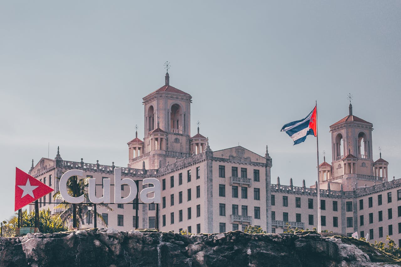 Historic building in Havana with Cuban flag and Cuba landmark sign
