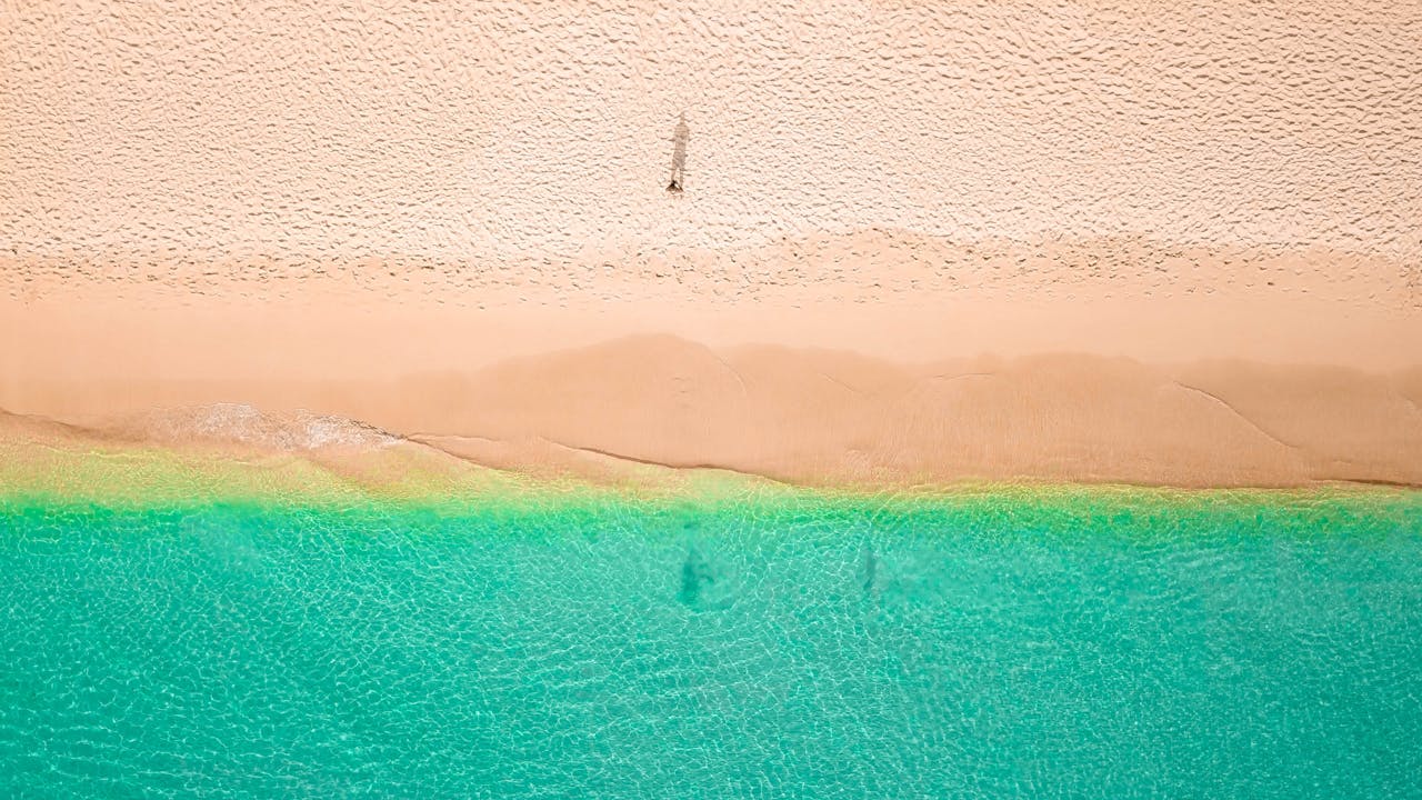 Aerial view of pristine tropical beach with turquoise water and sandy shoreline