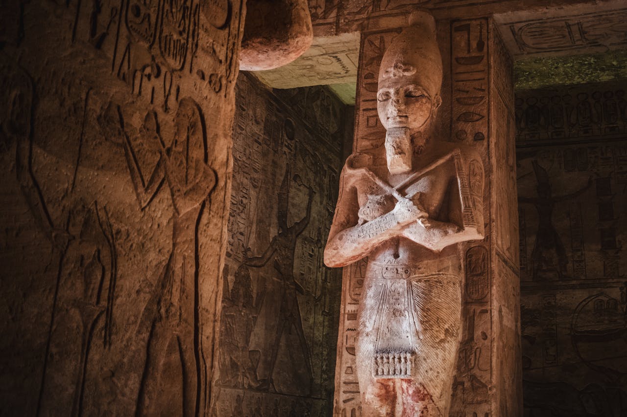 Ancient Egyptian pharaoh statue surrounded by hieroglyph-covered temple walls
