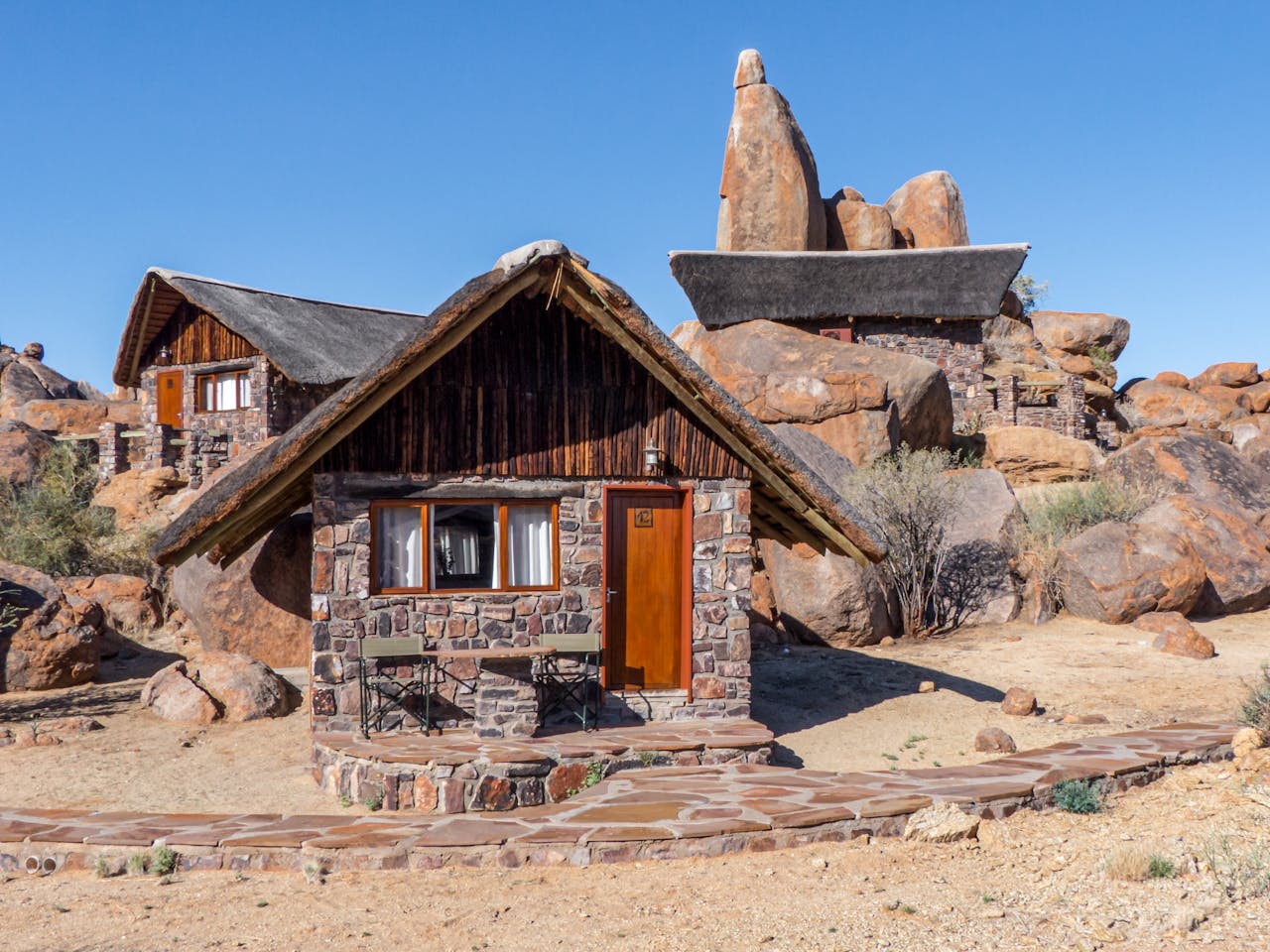 Rustic stone lodge surrounded by dramatic rock formations in Namibia