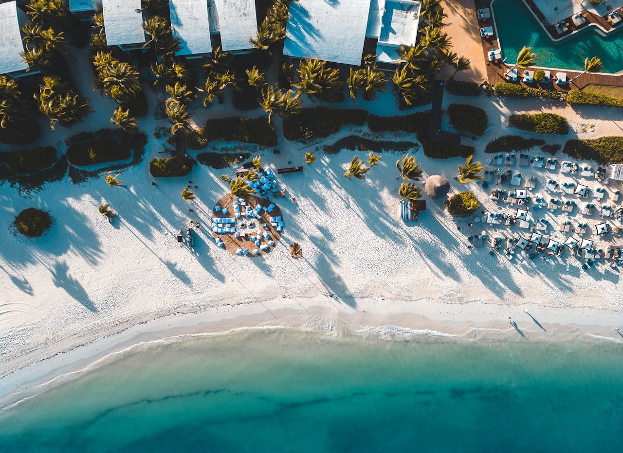 Aerial view of tropical beach resort with palm trees and turquoise water