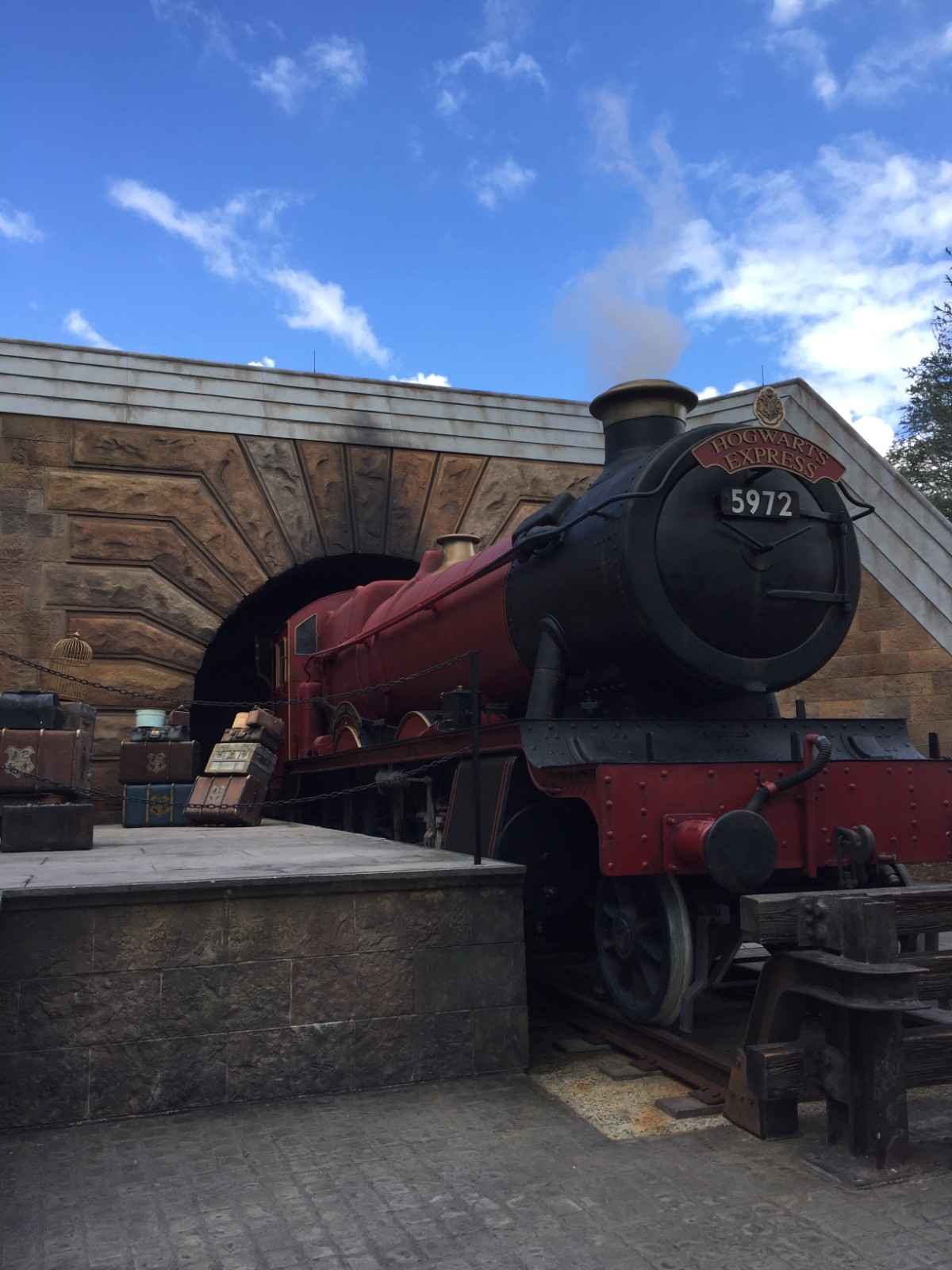 Hogwarts Express steam locomotive at a themed railway station