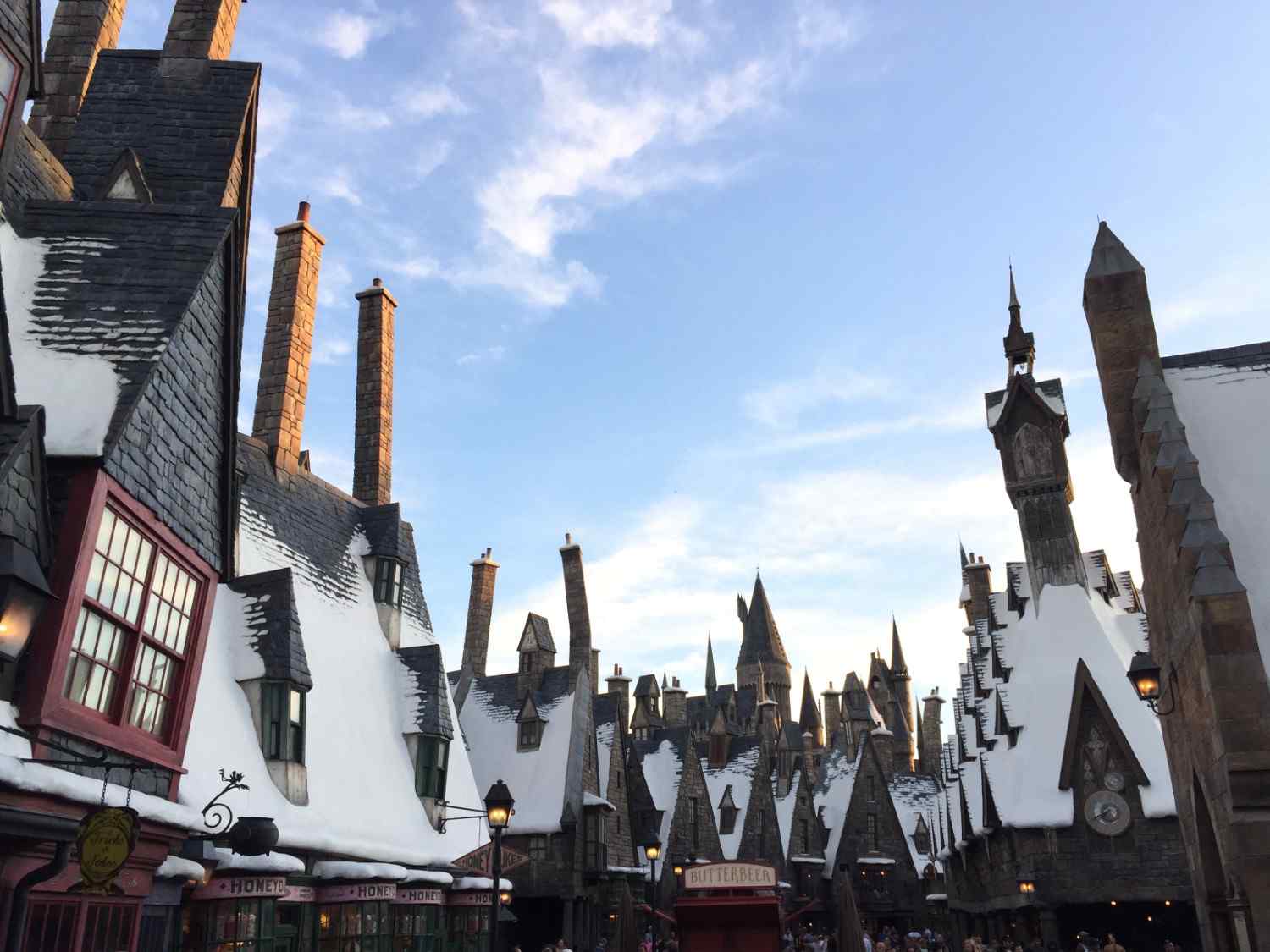 Snow-covered Hogsmeade village with themed shops and wizarding architecture