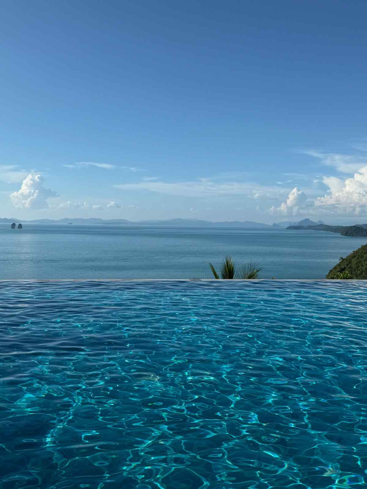 Infinity swimming pool overlooking a tranquil tropical sea and distant islands