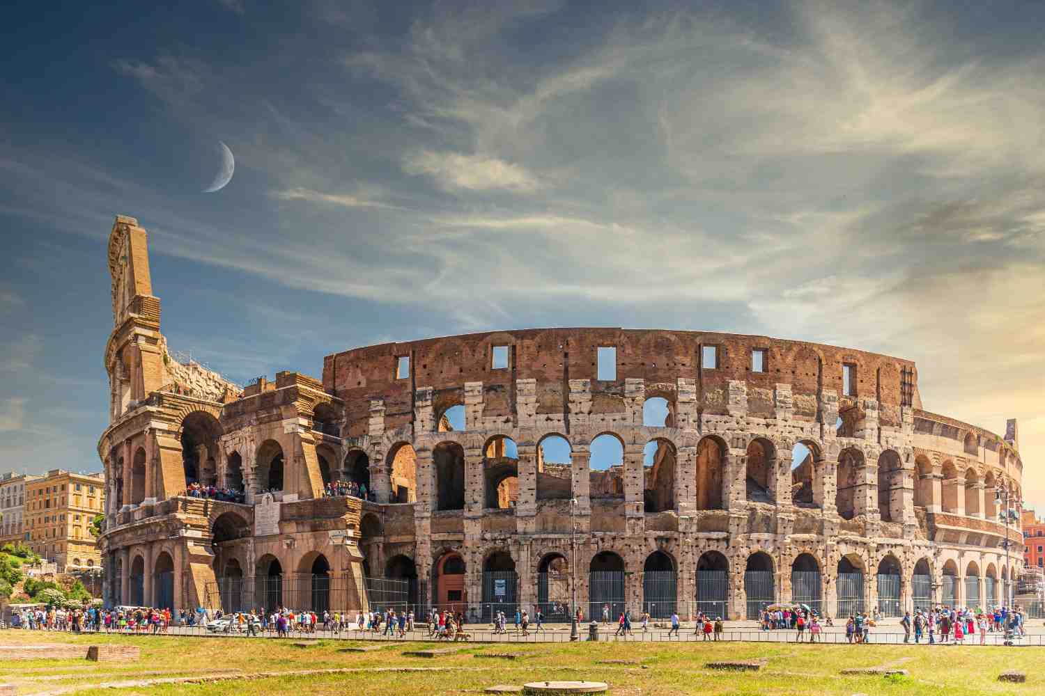 Ancient Roman Colosseum in Rome with tourists under a dramatic sky