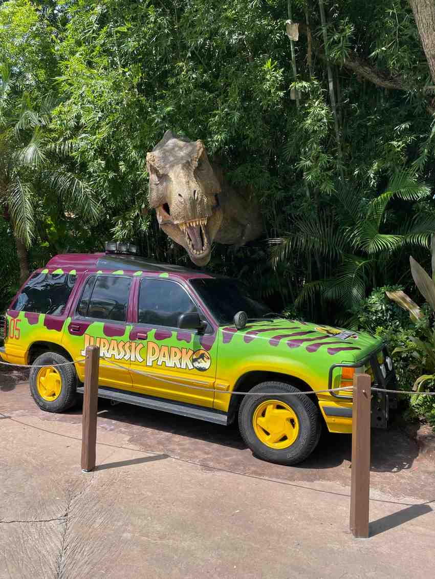 Jurassic Park vehicle with a large Tyrannosaurus rex emerging from tropical foliage