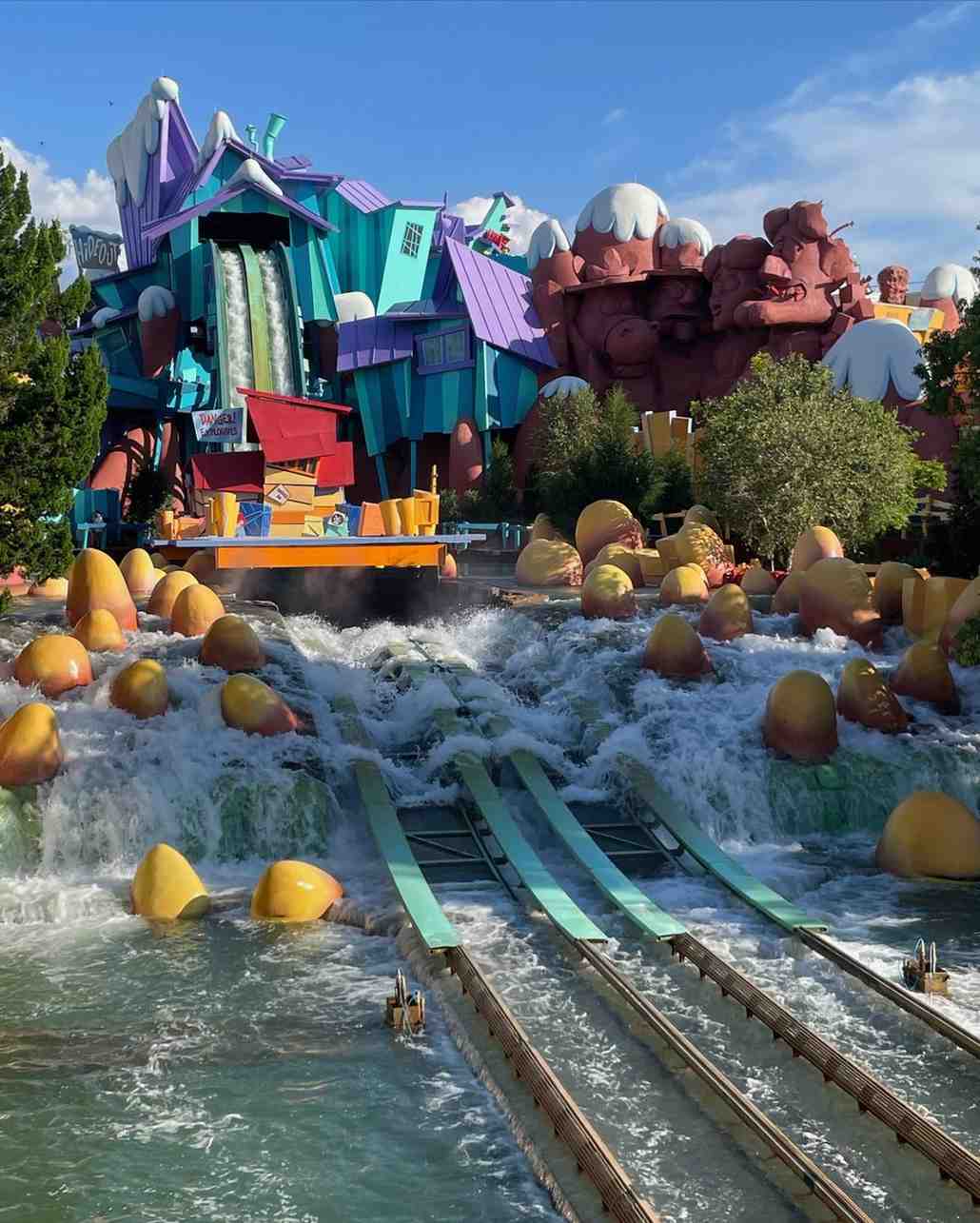 Colorful themed water ride with rushing rapids and whimsical buildings
