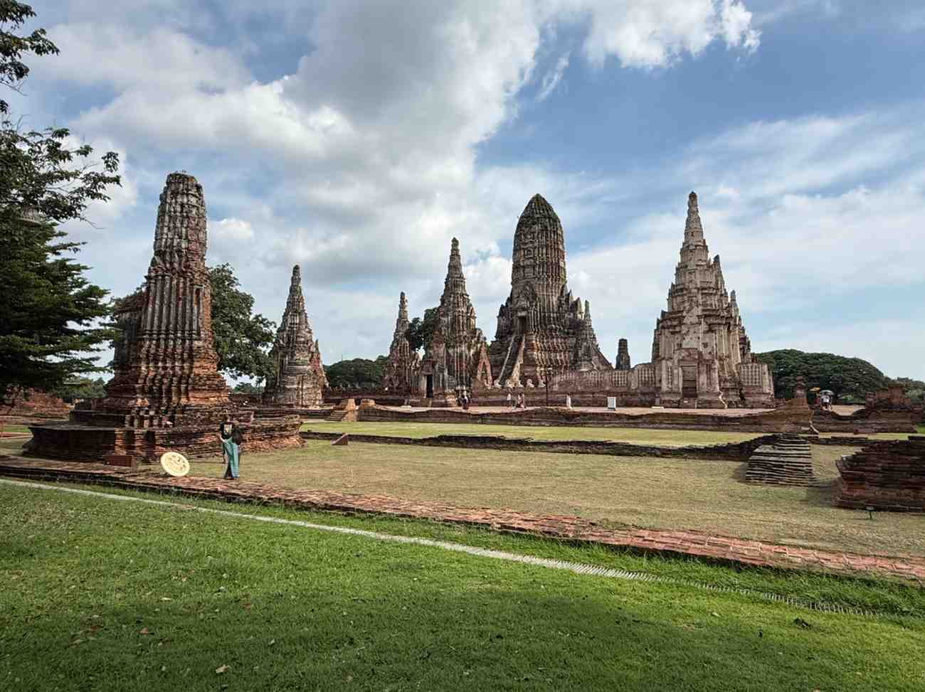 Historic temple ruins in Thailand featuring ancient stone towers and green grounds